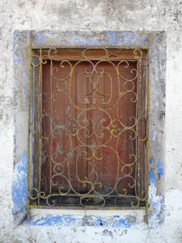 Janela com gradeamento em casa abandonada no campo do Alentejo